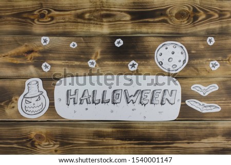 Sketch inscription Halloween, bats and evil pumpkin on wooden background