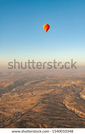 Aerial view of hot air balloons flying over turkish mountain landscape in the Goreme National Park, Cappadocia.