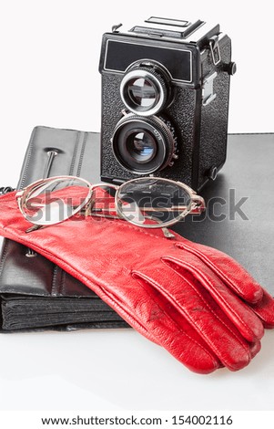 A pair of glasses on a red leather gloves