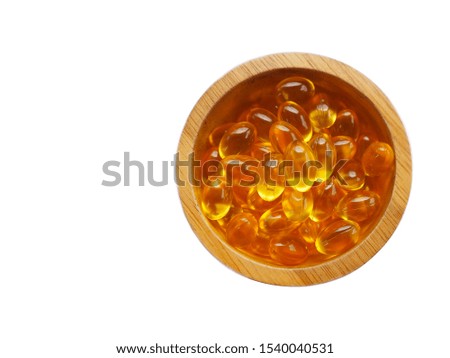Fish oil transparent capsules on wooden cup isolate on white background, Supplementary food  