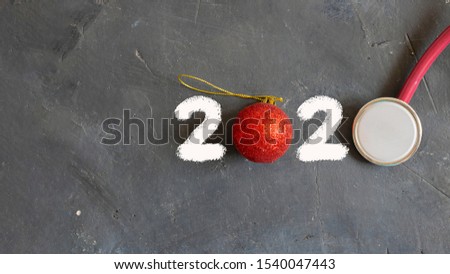 2020 of white drown two, red christmas ball as 0, one more mockup stethoscope on black chalk board, New year concept for professional doctors, medicine, health care and istrumets. Horizontal. Top view