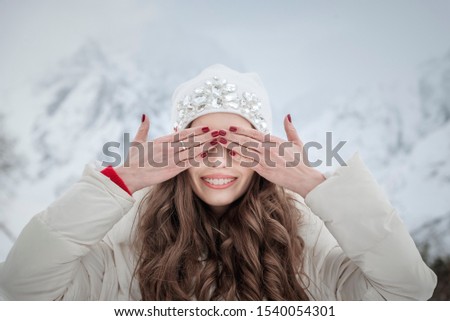 a young girl with braces closes her eyes while standing in the mountains.