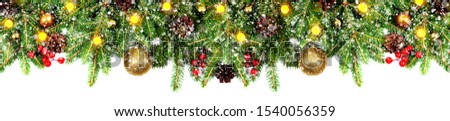 Amazing christmas border with fresh fir branches isolated on white. Golden balls, snow, cones, little light and red berries composition.