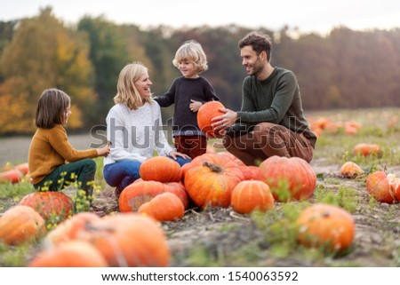 Happy young family in pumpkin patch field
