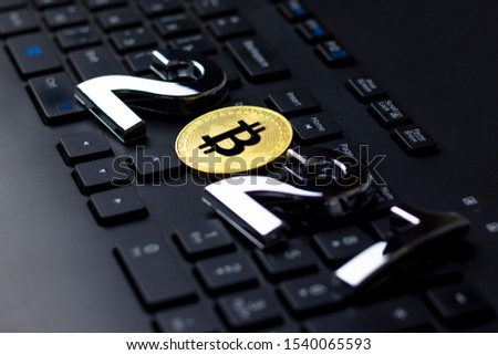 Gold bitcoin lies on a dark colored keyboard. close-up.
