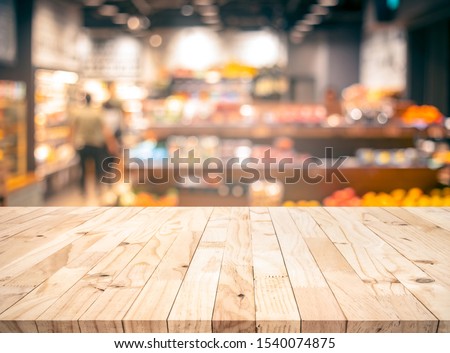 Wood texture table top (counter bar) with blur grocery,market store background.For montage product display or design key visual layout