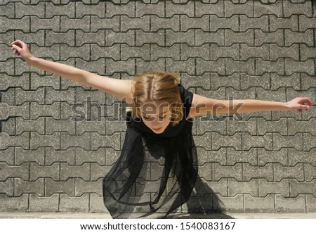 The top view of the teen ballerina on gray cobblestone background. young black bride. raise hands. closed eyes. 