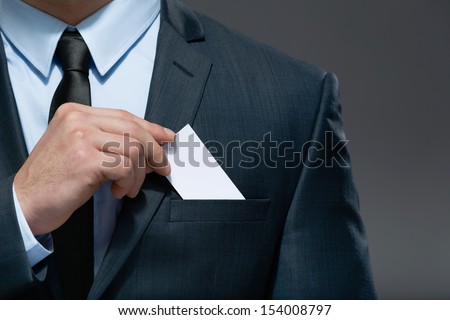 Part of body of business man who takes out business card from the pocket of business suit, copyspace