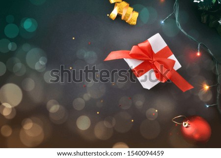 Christmas background with gifts and christmas decoration on black table with little stars and colored lights . Horizontal composition. Top view.