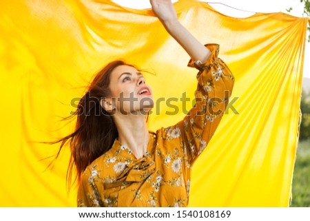 young woman looking at the camera with a yellow model cloth