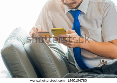 Technology, Shopping, Banking and Lifestyle concept - Man's hands holding smartphone and using credit card for online shopping.