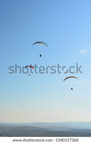Many paragliders simultaneously is flying in a clear blue sky on a sunny day in Hungary