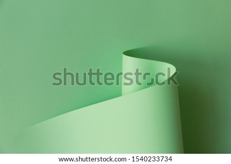 Abstract creative design of light green curve shaped paper on plain background. Monochrome geometric fashion poster. Empty space for copy, text, lettering. Royalty-Free Stock Photo #1540233734