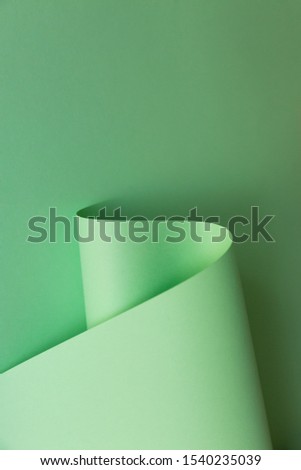 Abstract creative design of light green curve shaped paper on plain background. Monochrome geometric fashion poster. Empty space for copy, text, lettering.