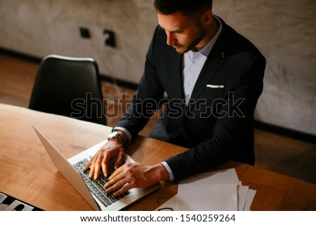 Boss working at the office. Man working on a laptop in his office.