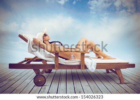 Beautiful girl relaxing on a deckchair in the beach
