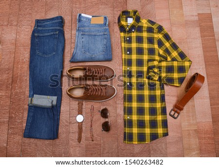 Men's casual outfits with man accessories on brown wooden board background
