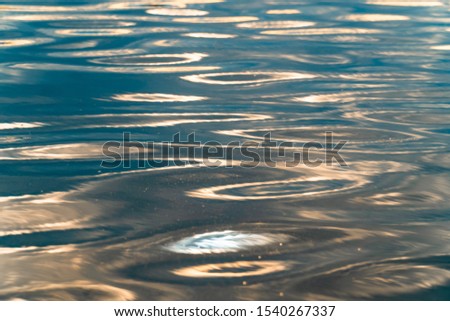 Reflection of golden sunset sky on the water surface.