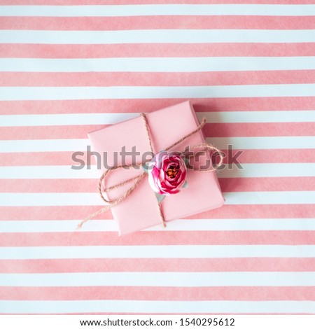 Pink gift box with a pink ribbon on a pink background .