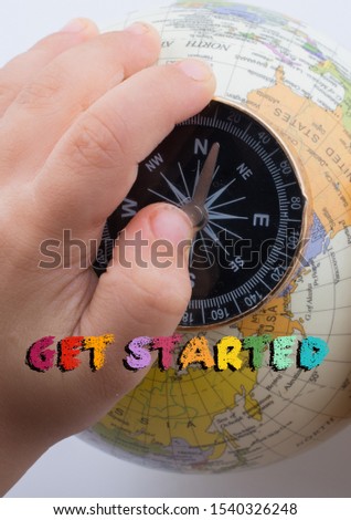 Hand holding compass on globe with  Get Started wording on it