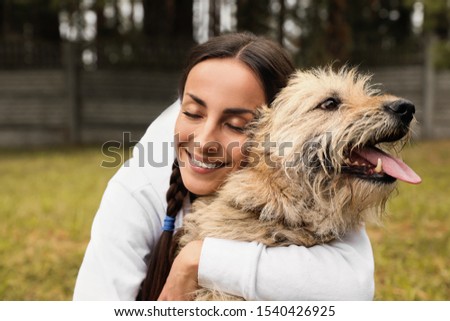 Female volunteer with homeless dog at animal shelter outdoors Royalty-Free Stock Photo #1540426925