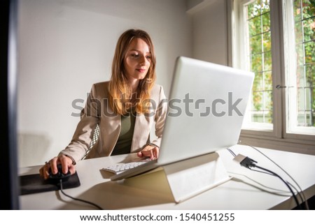 Young beautiful woman looking at computer