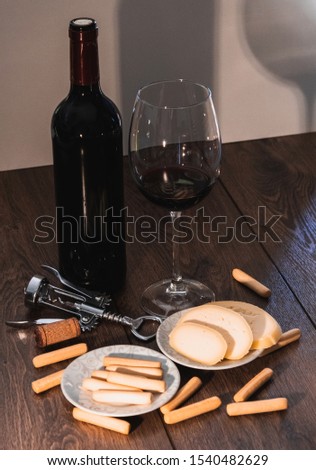 glass of wine and wine bottle with cheese