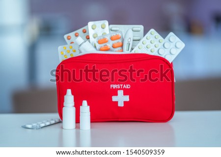 Medical first aid kit with medicine and pills on table at home 
