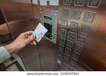 Person using a key card in an elevator 