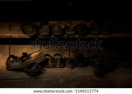 school shoes / student shoes arranged orderly on shoe rack with dramatic lighting and warm white balance from camera