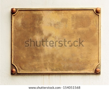 Old brass yellow metal plate framed and nailed on white stone wall background