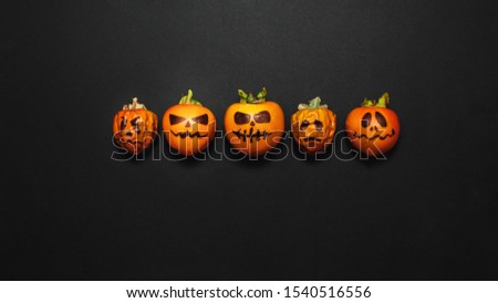 Family generation Halloween concept. Festive still life  pumpkins family on black background. Top view flat lay