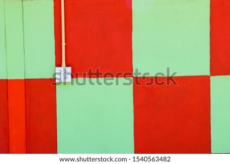 Green and red wall with power plugs background image