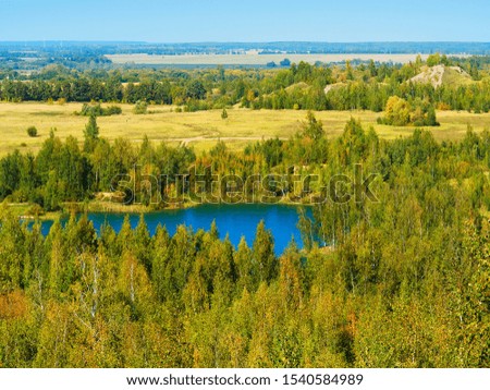 Dramatic blue lake surrounded by green forest landscape background