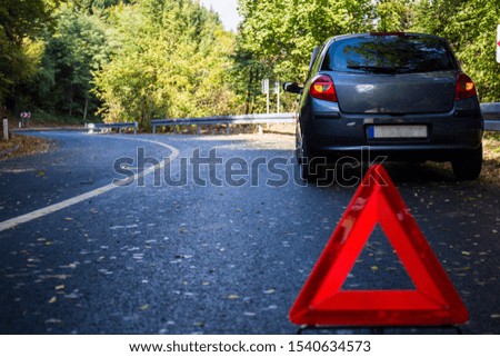 Road breakdown car in nature, forest, autumn, roadside assistance, triangle as a warning sign