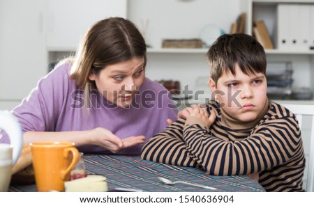 Upset boy and angry mother having quarrel during breakfast at home Royalty-Free Stock Photo #1540636904