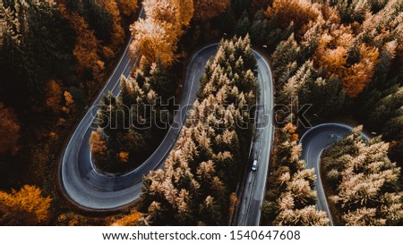 Details of drone shots - airborne photography, Top view of curved asphalt road in mountain forest