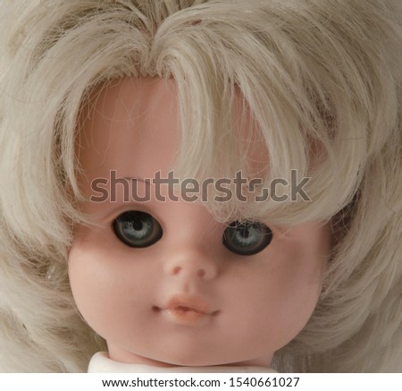 The face of an old Soviet doll with white hair close-up. Children's toy.
