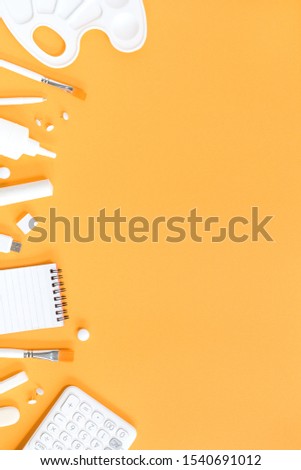 Assorted office and school white stationery on pastel orange background. Flat lay with copy space for back to school or education and crafts concept