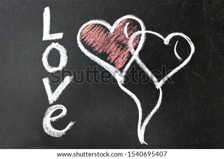 The inscription on the blackboard with chalk. Valentine`s day theme. Dark grunge texture blackboard. Love. I love you. Message of love. The inscription on the blackboard with chalk. Valentine`s day .