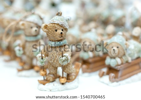 Decorative figurines of a Christmas theme. Statuette of a teddy bear on a wooden sleigh. Christmas tree decoration. Festive decor, warm bokeh lights