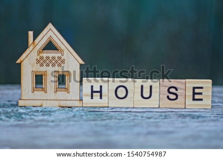house layout and word made of wooden letters on gray table