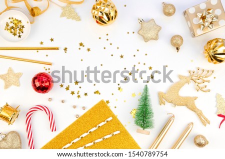 Flat lay xmas arrangement in gold and white colors: Christmas decorations. candy cane and gifs on White background