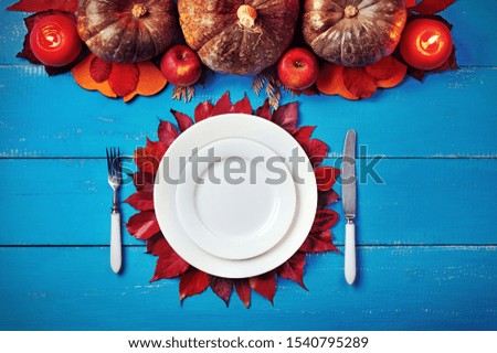 Low key picture of a served dinner with pumpkins decoration