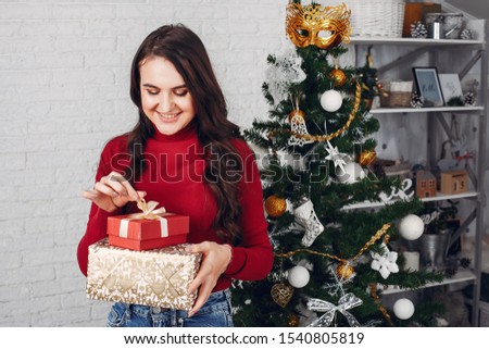 Beautiful girl in a photo studio. Woman near Christmas tree. Lady in a red sweater