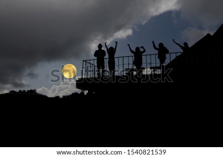 People on terrace with full moon in the evening