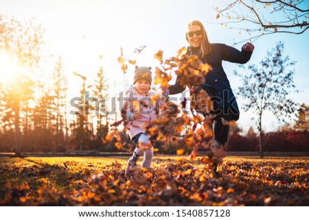 Mom and daughter having fun at the park. Fall season
Kicking tree leaves on the ground, smiling. Playing activities in the park. Mother and little daughter playing together in a park Royalty-Free Stock Photo #1540857128
