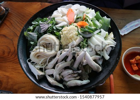 The Korean food in the picture is called "Jeongol" (with fresh vegetables and Seafood stew). 
When you order this food, you boil it directly at the table and eat.