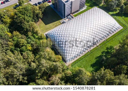 dome of inflatable tennis court in park in summer. aerial view of sports centre Royalty-Free Stock Photo #1540878281