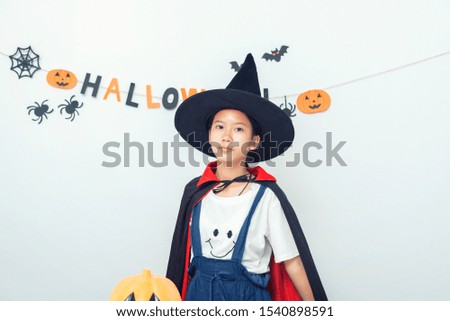Asian girl witch costume playing in the room Happy Halloween trick or treat concept.
